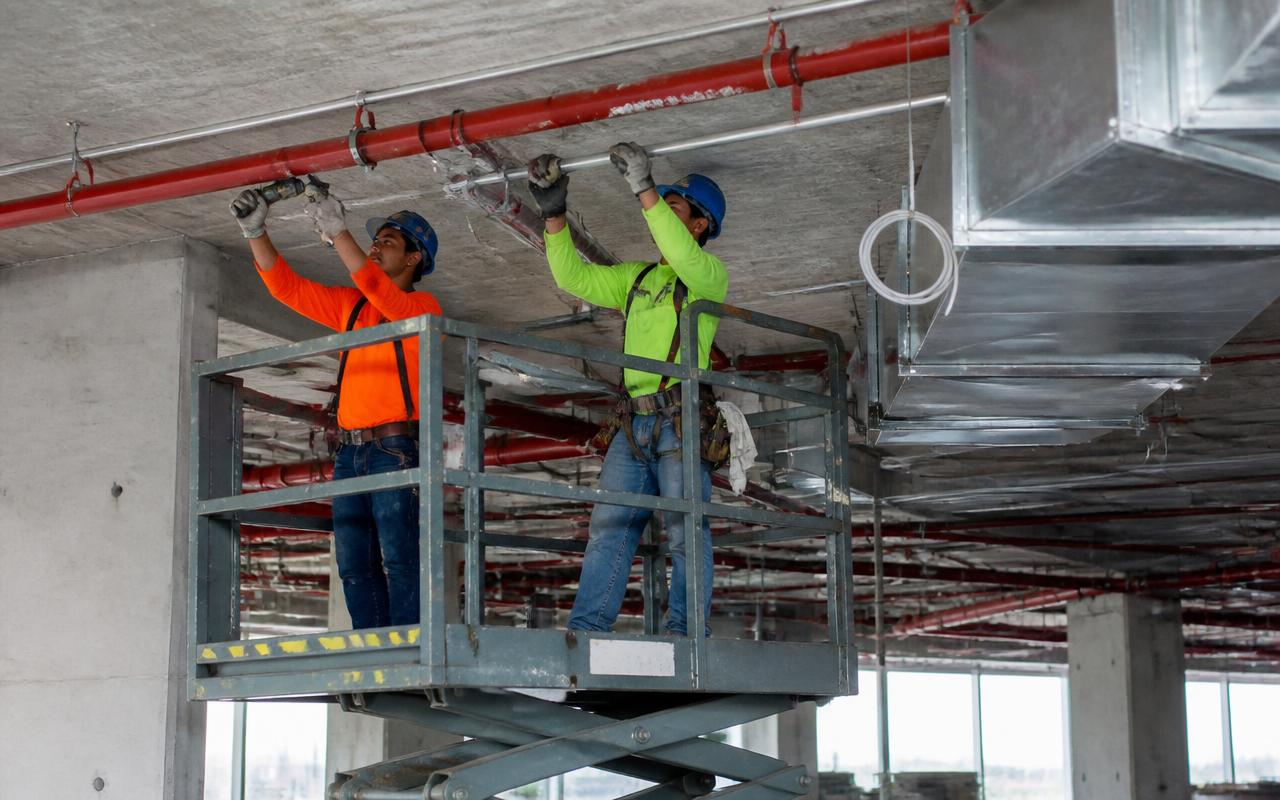Fire sprinkler installation crew fitting red sprinkler pipe in a commercial building in Phoenix, Arizona